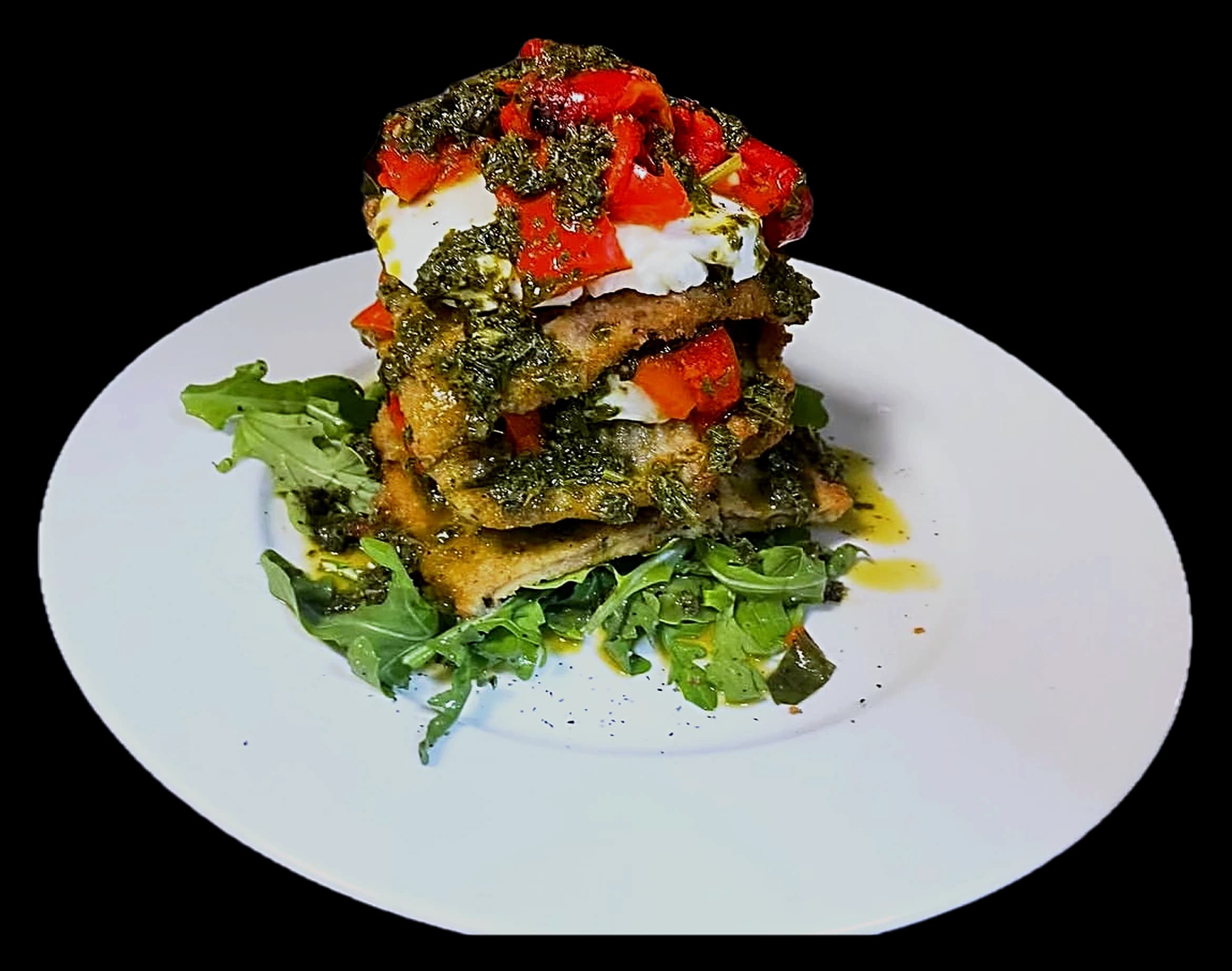 Eggplant Della Nonna — breaded eggplant layered with fresh mozzarella, roasted red peppers and herbs over greens