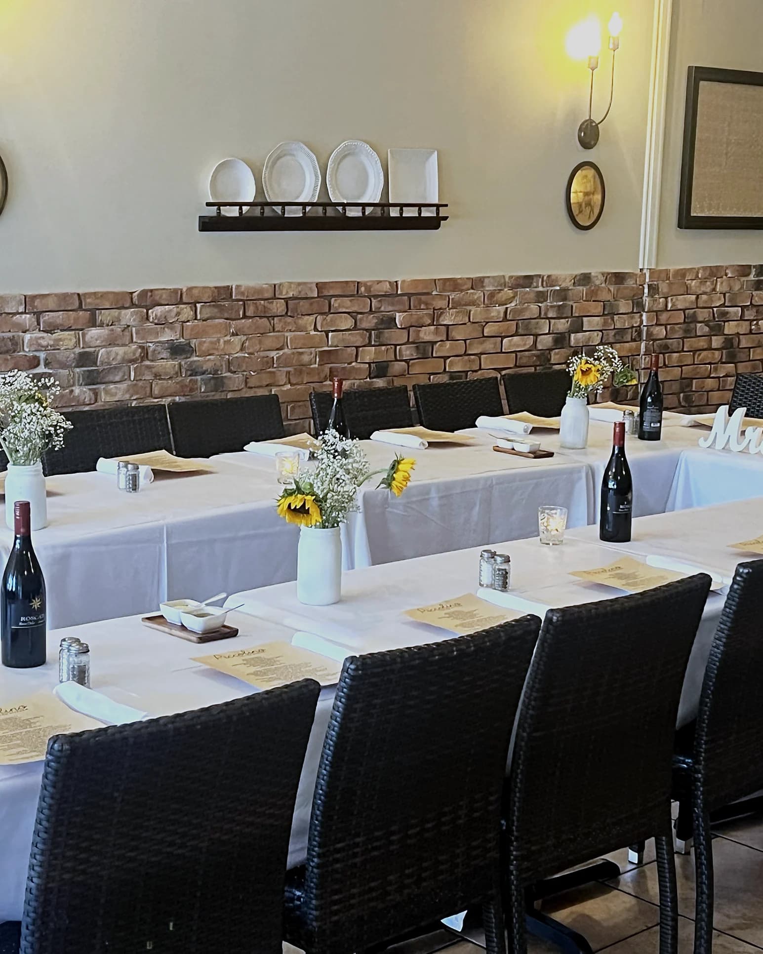 The dining room set for a private party, sunflowers and wine on every table